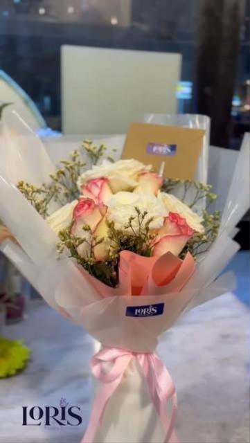 Pastel rose bouquet wrapped in blush paper by Loris